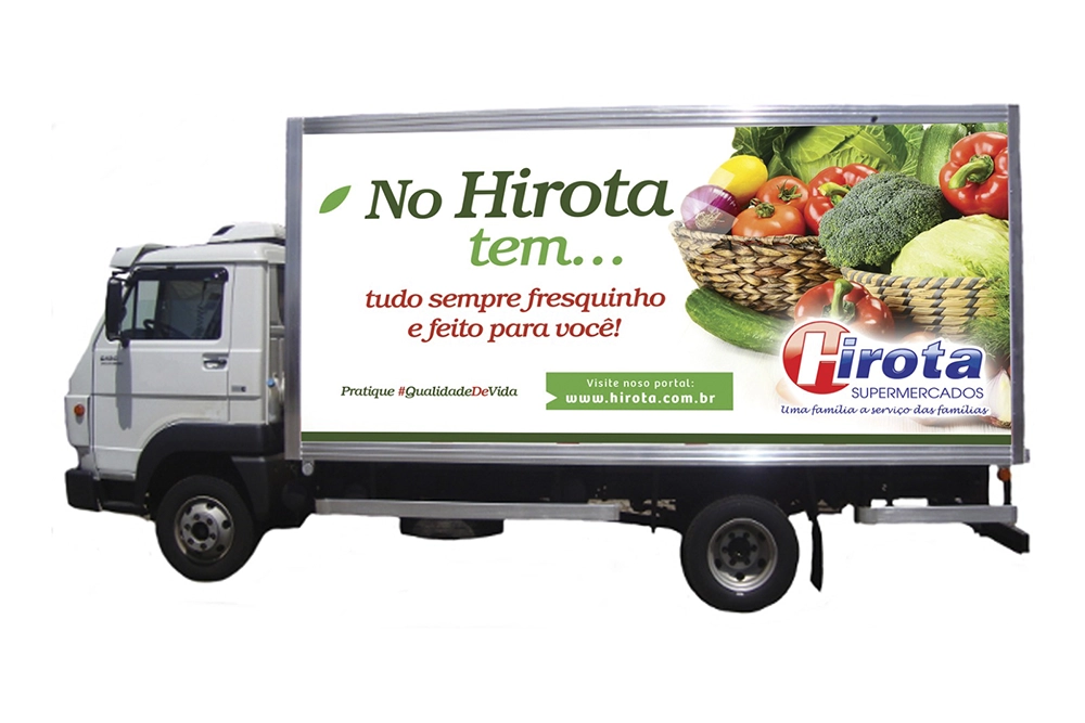 Delivery truck with a large grocery advertisement showing fresh vegetables and the Hirota Supermercados logo for promotion of groceries.